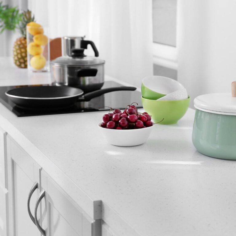 A kitchen with a white counter top and bowls of fruit that showcases 5 Kitchen Upgrades.