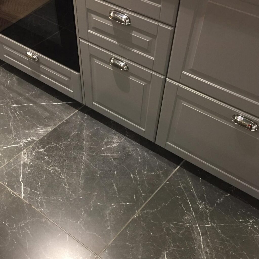 Upgrade your kitchen with stylish grey marble floors and sleek drawers.
